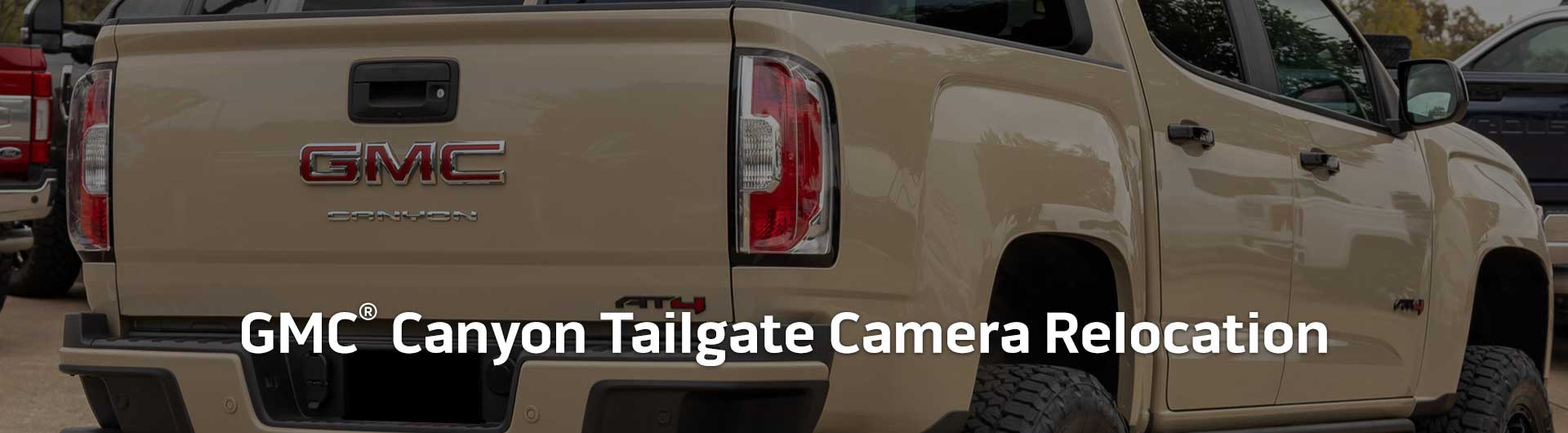 An image showing the tailgate of a GMC Canyon truck. Text overlaid onto the image reads GMC Canyon Tailgate Camera Relocation