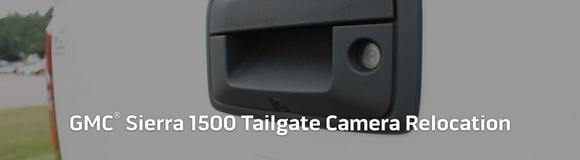 An image showing the tailgate of a GMC Sierra 1500 with a backup camera built into the tailgate handle.