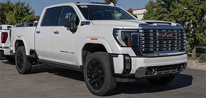 An image showing a white GMC Sierra 2500 Denali truck in a parking lot.