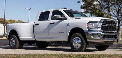 An image showing a white RAM 2500 truck in a parking lot.